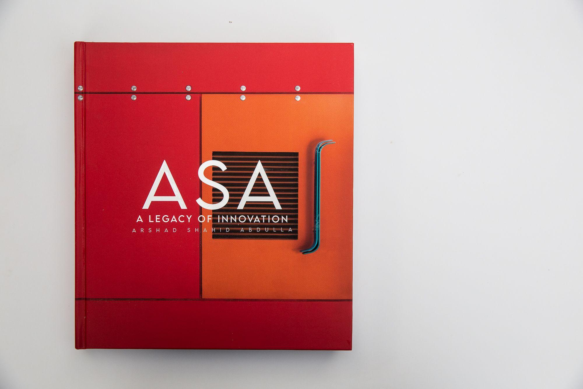 The legacy book, red cloth cover, closed.